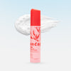 Pink uncap skincare product with red cap on a light blue background